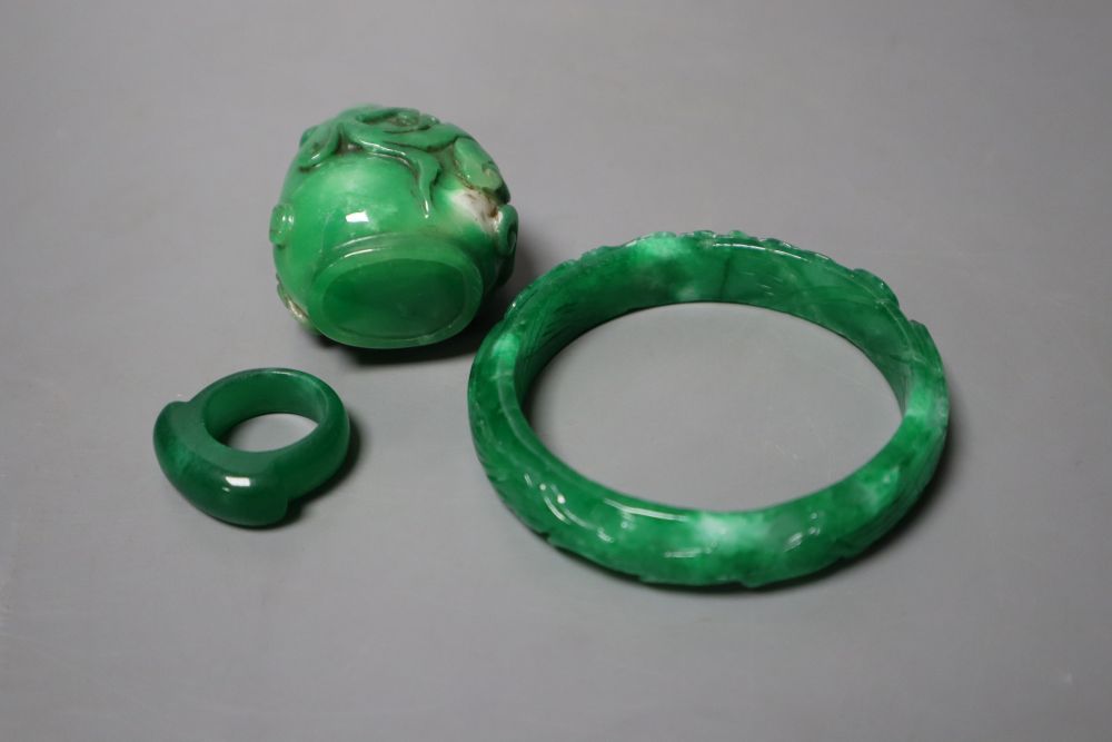 A Chinese green jadeite snuff bottle and stopper, a similar phoenix & dragon bangle and an archers ring